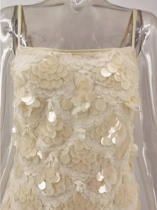 Detail of cream sequin strapless top showing overlapping pearl-like fish scale patterns