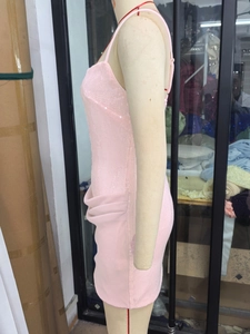 Détail de la robe de cocktail à paillettes rose clair avec drapé latéral élégant
