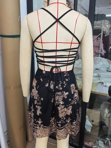 Detail of sequin party dress featuring an open back with intricate crisscross strap design