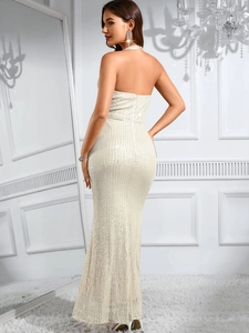 Macro shot of shimmering white sequins and backless halter design on evening gown