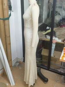 Detailed close-up of champagne sequins on backless floor-length evening gown
