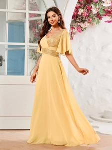 Détails de robe de soirée jaune avec col en V et broderies de paillettes dorées