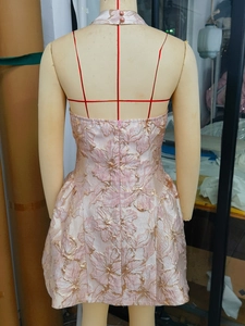 Détail du dos nu sur une robe de soirée en jacquard rose avec fermeture éclair invisible