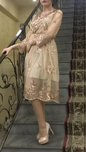 Gros plan détaillé des paillettes champagne sur une robe de soirée en tulle transparent