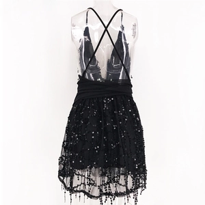 Close-up of black sequin mini dress with cross back straps and shimmering fringe hemline