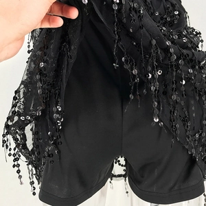 Detail of black sequin tassel skirt with built-in safety shorts for night party wear