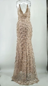 Détail d'une robe de soirée à paillettes champagne doré avec dos nu et lacets croisés