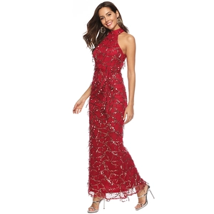 Détail d'une robe rouge sans manches à licou avec sequins dorés et finitions franges