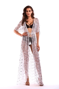 Detail of white sheer mesh cover-up featuring silver sequins and fringe drawstring