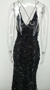 Détail d'une robe de soirée à paillettes avec dos nu plongeant et fines lanières