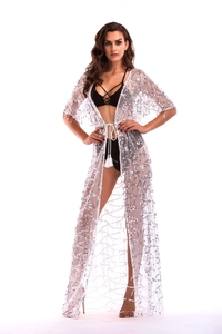 Detail of white sequined cover-up with silver patterns and tassel drawstring waist