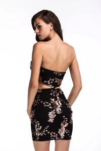 Close-up of rose gold floral sequin embroidery and side cut-out on a black party dress