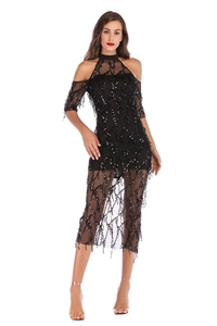 Detail of black off-shoulder dress featuring shimmering sequins and delicate fringe hem