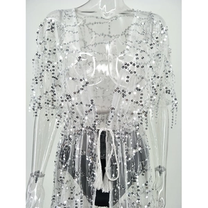 Detail of white mesh blouse featuring silver sequins, geometric patterns, and tassel ties