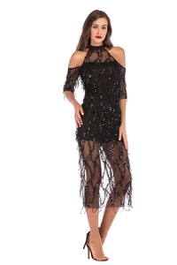 Close-up of sequined tassels and sheer mesh fabric on a sexy black evening dress