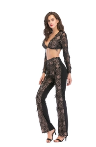 Détail du haut à manches longues en dentelle noire et pantalon évasé à franges scintillantes