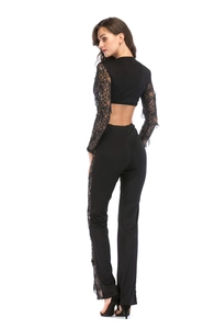Détail des manches en dentelle transparente avec paillettes sur une combinaison noire chic
