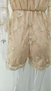 Détail d'un combishort en dentelle beige avec broderie florale et texture en tulle