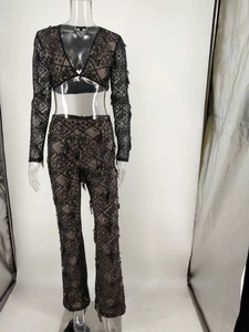 Détail d'un ensemble deux pièces en dentelle noire bohème avec haut en V et pantalon