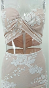 Detailed view of intricate white floral sequin embroidery on nude mesh cutout dress