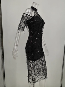 Detailed view of black sequin tassel embroidery on sheer mesh evening dress fabric