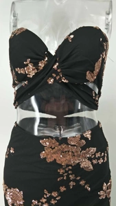 Detailed view of rose gold sequin floral embroidery on a black cut-out cocktail dress