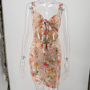 Close-up of sequined floral short dress featuring a large front bow and side cut-outs