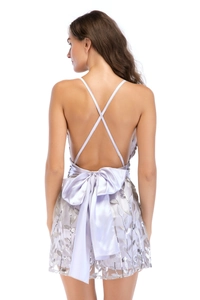 Détail de la dentelle à paillettes et du nœud en satin sur robe de soirée dos nu