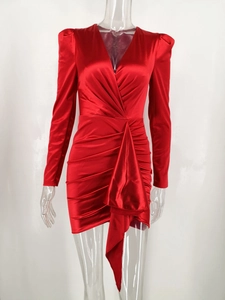 Detail of red satin long sleeve mini dress featuring deep V-neck and ruched draped design