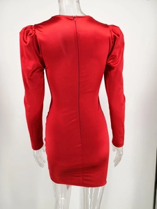 Detail view of the back zipper and bubble long sleeves on a red satin dress