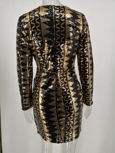 Detail eines Paillettenkleides mit schwarz-goldenen geometrischen Zickzack-Mustern