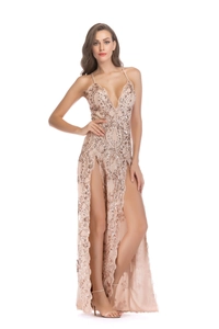 Détail d'une robe de soirée à paillettes or rose avec fente haute et col en V profond