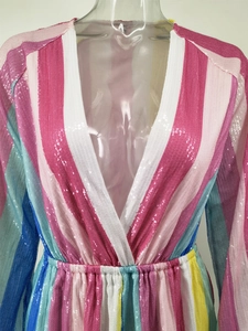 Detail of multi-colored rainbow sequin fabric and V-neckline on long sleeve jumpsuit