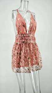 Détail de sequins rose corail avec motifs de feuilles dorées sur tissu en maille filet