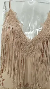 Detail of champagne sequin dress with delicate lace V-neck and tiered fringe accents