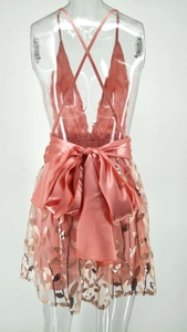 Détail de la robe de soirée rose à paillettes avec dos nu et grand nœud en satin