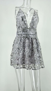 Détail de la broderie de paillettes argentées sur une mini robe de soirée sexy