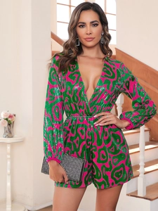 Detail of sequined long sleeve jumpsuit with deep V-neck in green and pink pattern