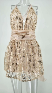 Détail de la broderie à paillettes et des motifs dorés sur une robe de soirée champagne