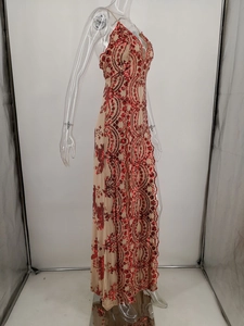 Détail de la broderie à paillettes rouges sur une robe de soirée longue beige