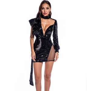 Détail d'une robe à paillettes avec col en V profond, empiècement en mesh et design asymétrique