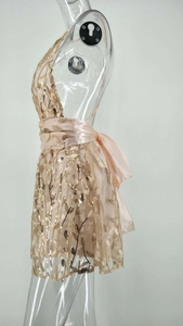 Détail de la robe de soirée rose champagne avec paillettes dorées et nœud en satin