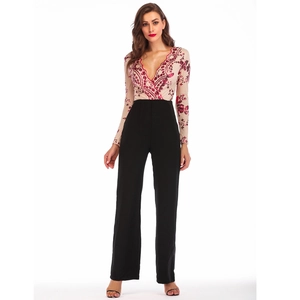 Detail view of sheer mesh top with red sequin embroidery and black high-waisted pants
