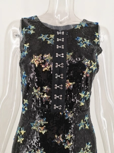 Close-up of black sequin dress with colorful star patterns and metal hook closure