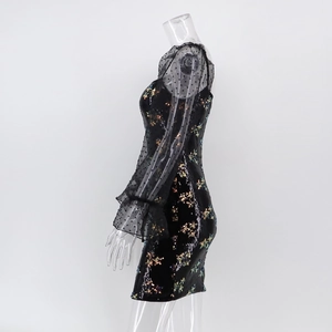 Détail des manches en résille à pois et sequins floraux sur une robe moulante noire