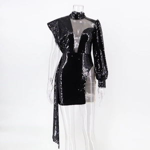 Détail de la robe à paillettes noire asymétrique avec empiècement en résille et fente