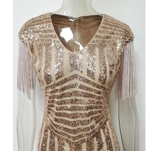 Détail d'une robe à paillettes champagne doré avec col en V et manches à franges