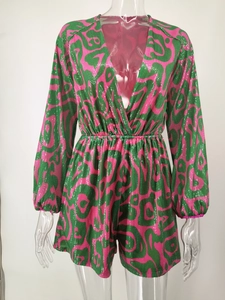 Detail of pink and green sequin romper with a sexy deep V-neck and long sleeves