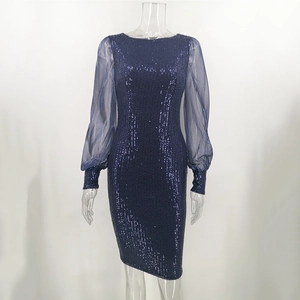 Detail of dark blue sequin dress featuring sheer mesh puff sleeves and sparkling texture