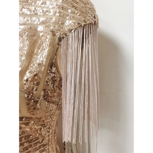 Détail des paillettes dorées scintillantes et des franges élégantes de cette robe chic